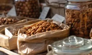 Sacchetti di carta pieni di mandorle, invitano a chiedersi quante mandorle al giorno siano ideali per uno spuntino sano.
