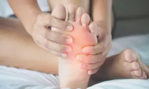 Mani che massaggiano un piede, evidenziando il dolore sotto le dita. Si cercano rimedi naturali per alleviare il fastidio.