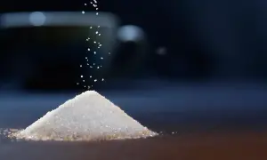 Granello di zucchero cade su una piramide. Il sucralosio, un dolcificante, è un'alternativa per chi soffre di diabete.