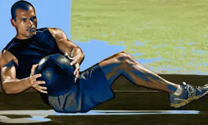 Uomo che esegue addominali con la palla, concentrato sul suo allenamento.