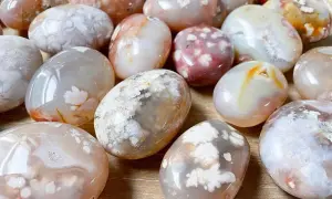 Un gruppo di pietre di agata, con inclusioni bianche che ricordano fiori. L'agata pietra significato è legato alla serenità e alla crescita.