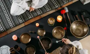 Operatore olistico stipendio: ciotole tibetane, candele e bacchette per un massaggio sonoro rilassante.