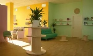 Salone moderno con pareti giallo e verde menta. Il colore azzurro significato di tranquillità è evocato dal divanetto, mentre le piante portano vitalità.