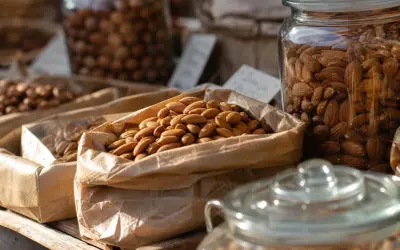 Sacchetti di carta pieni di mandorle, invitano a chiedersi quante mandorle al giorno siano ideali per uno spuntino sano.