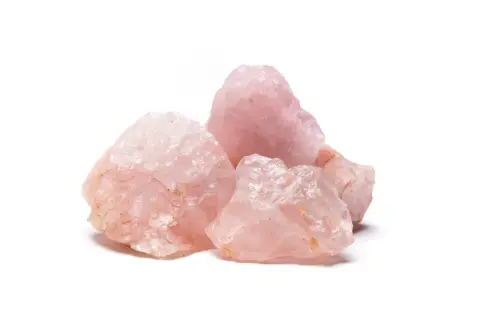 Gruppo di grezzi cristalli di quarzo rosa, noti per il loro significato legato all'amore e alla guarigione.