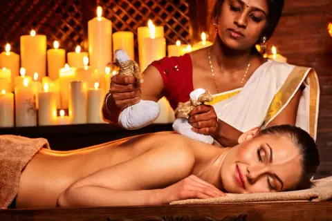 Massaggio ayurvedico con sacchetti di erbe calde. Informarsi sulle controindicazioni prima del trattamento.