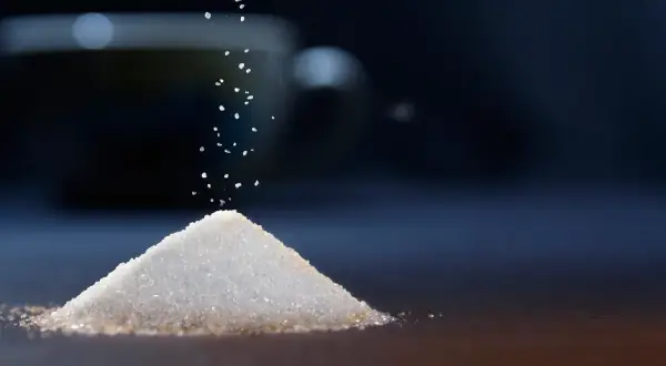 Granello di zucchero cade su una piramide. Il sucralosio, un dolcificante, è un'alternativa per chi soffre di diabete.