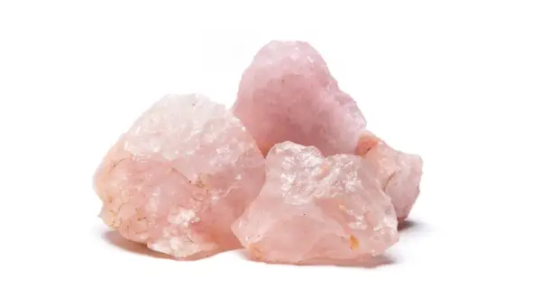 Gruppo di grezzi cristalli di quarzo rosa, noti per il loro significato legato all'amore e alla guarigione.