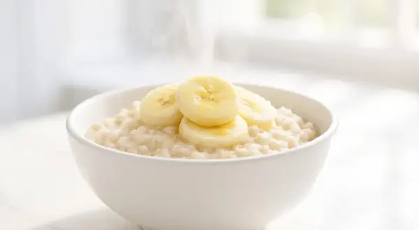 Una ciotola di porridge caldo con fette di banana. Attenzione: il porridge senza cottura fa male.