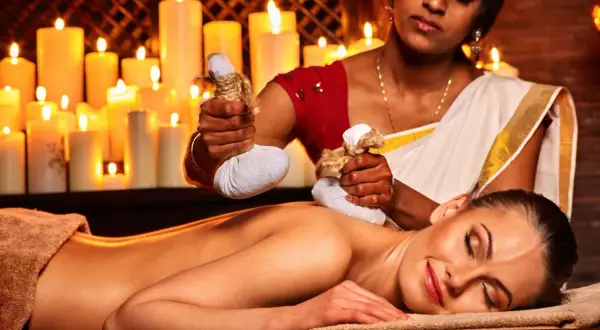 Massaggio ayurvedico con sacchetti di erbe calde. Informarsi sulle controindicazioni prima del trattamento.
