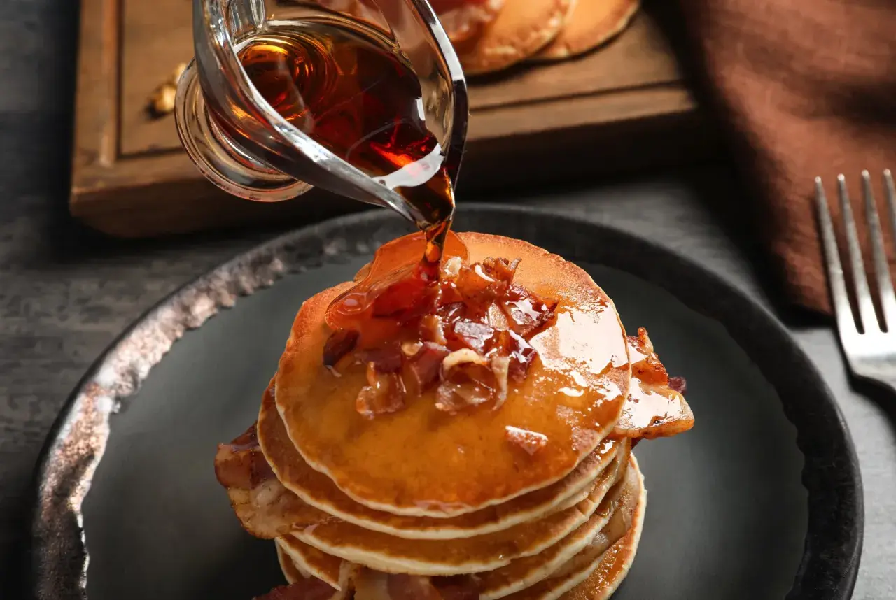 Pancakes con sciroppo d'acero e bacon. Meglio sciroppo d'acero o agave? La scelta è tua per questa delizia.