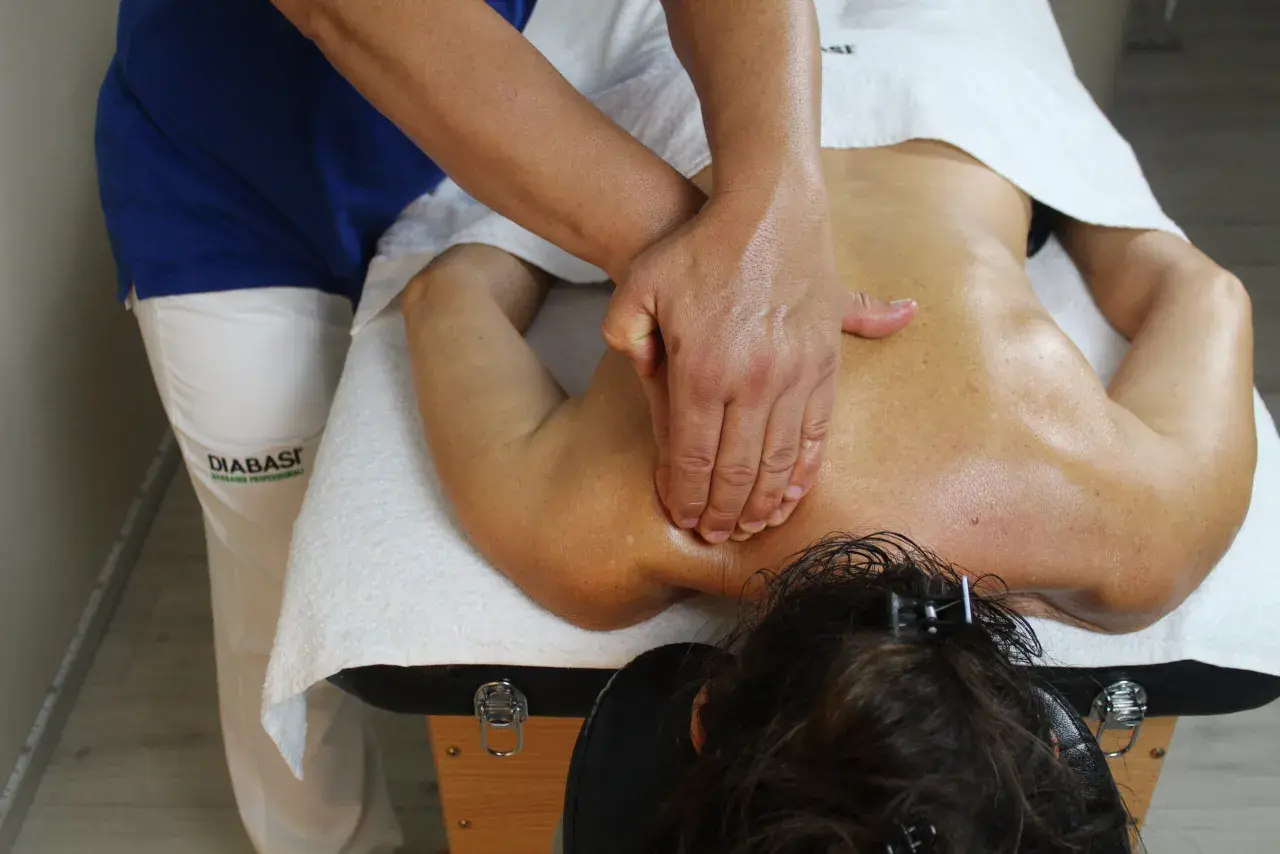 Massaggio terapeutico per alleviare il dolore al nervo sciatico. Le mani esperte lavorano sulla schiena per sciogliere le tensioni.