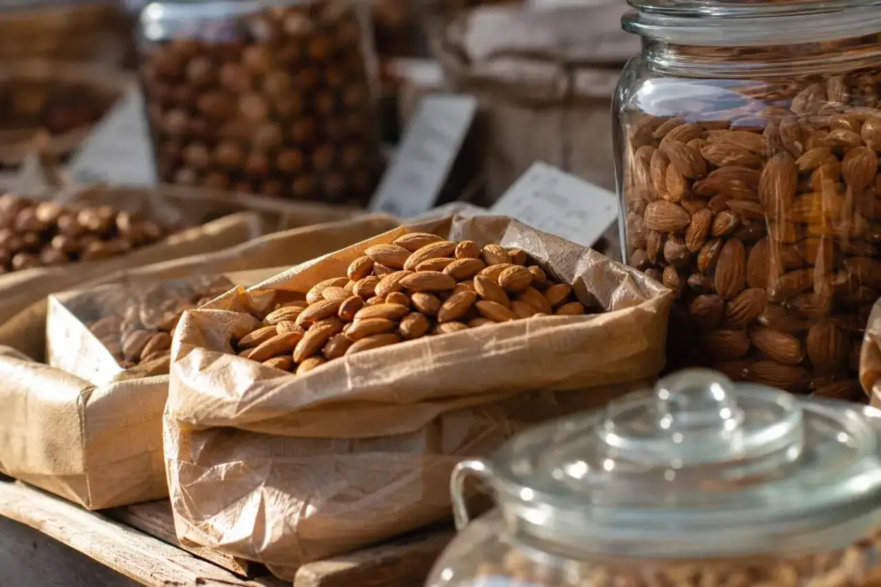 Sacchetti di carta pieni di mandorle, invitano a chiedersi quante mandorle al giorno siano ideali per uno spuntino sano.