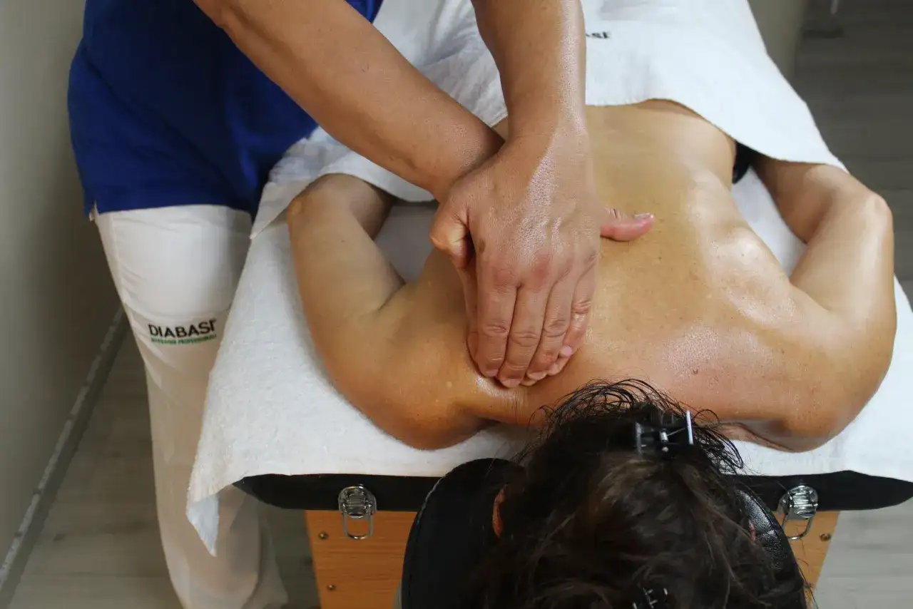 Massaggio terapeutico per alleviare il dolore al nervo sciatico. Le mani esperte lavorano sulla schiena per sciogliere le tensioni.