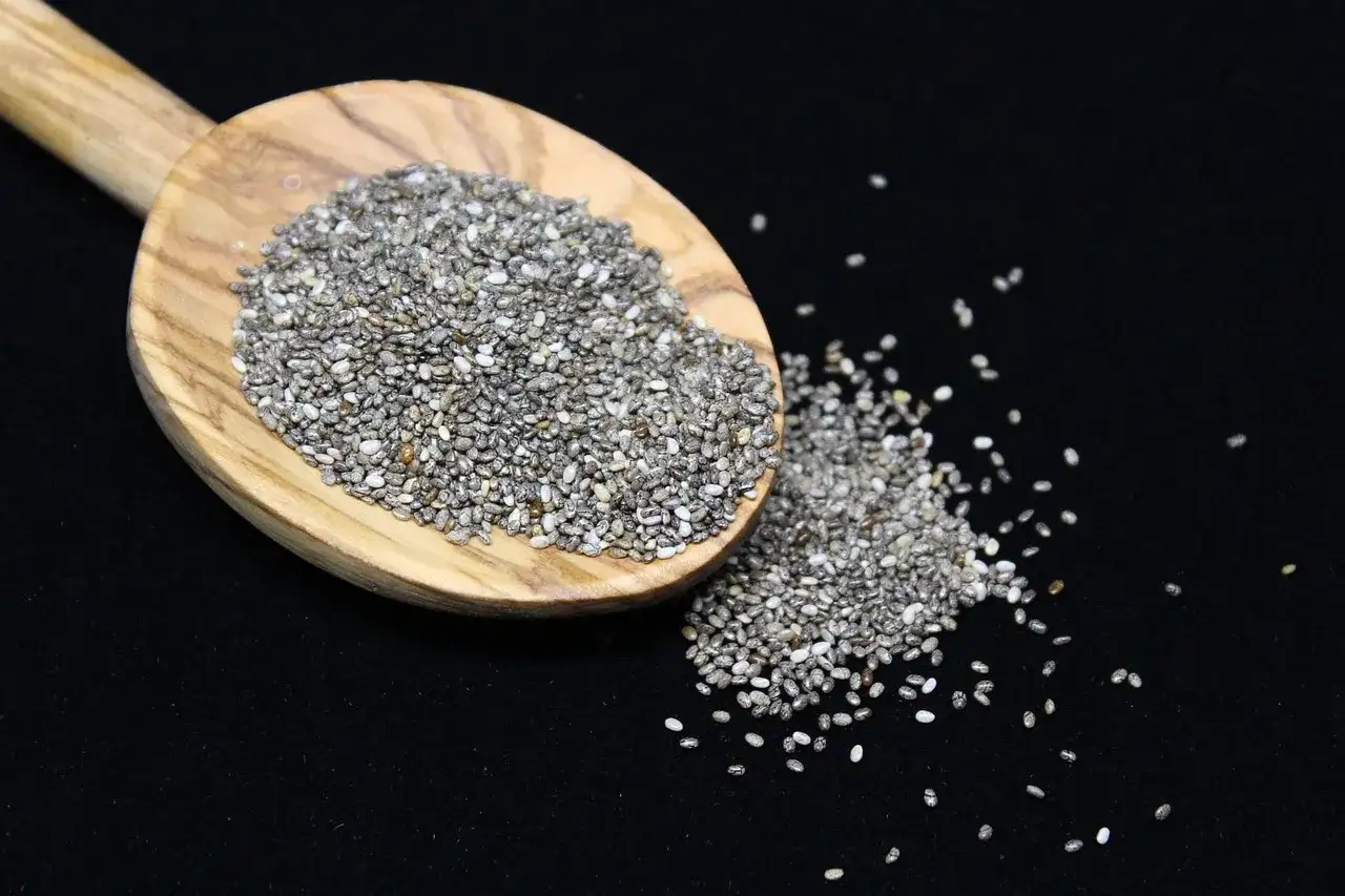 Semi di chia su un cucchiaio di legno, un aiuto naturale per la menopausa.