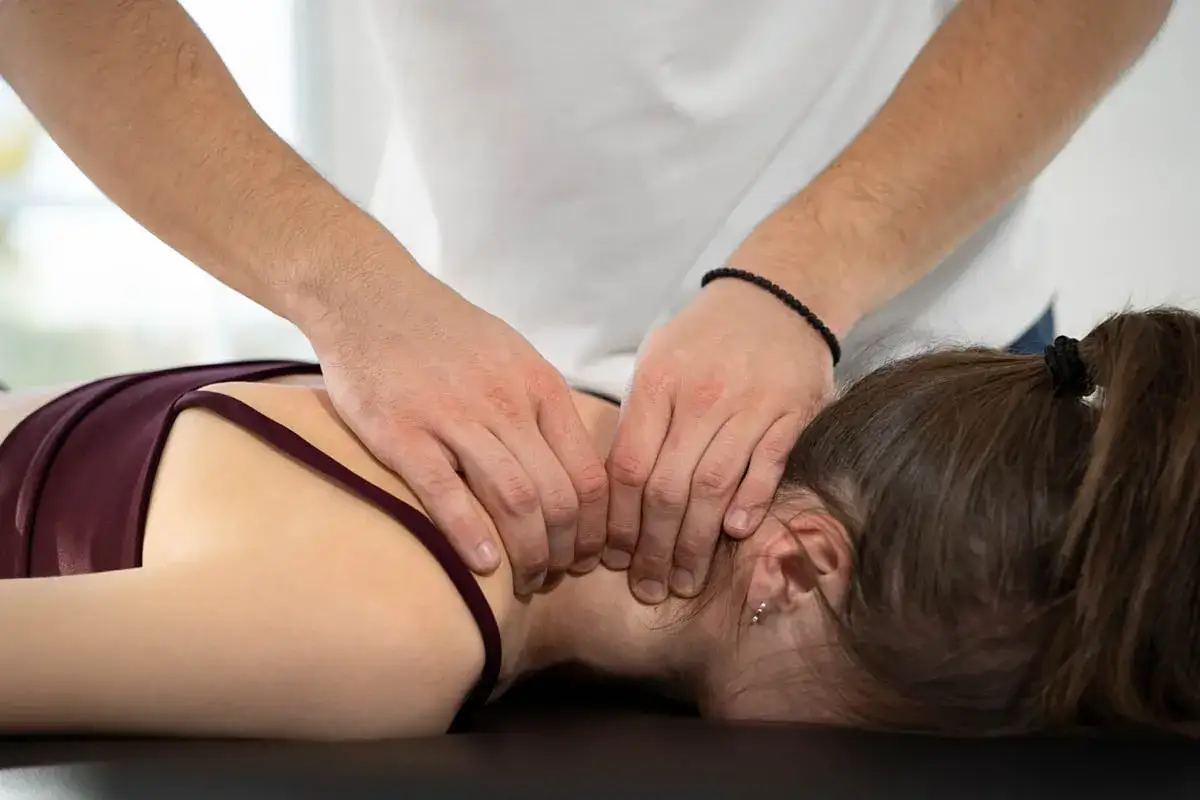 Mani esperte massaggiano il collo, sperando di alleviare il malessere dopo massaggio cervicale.