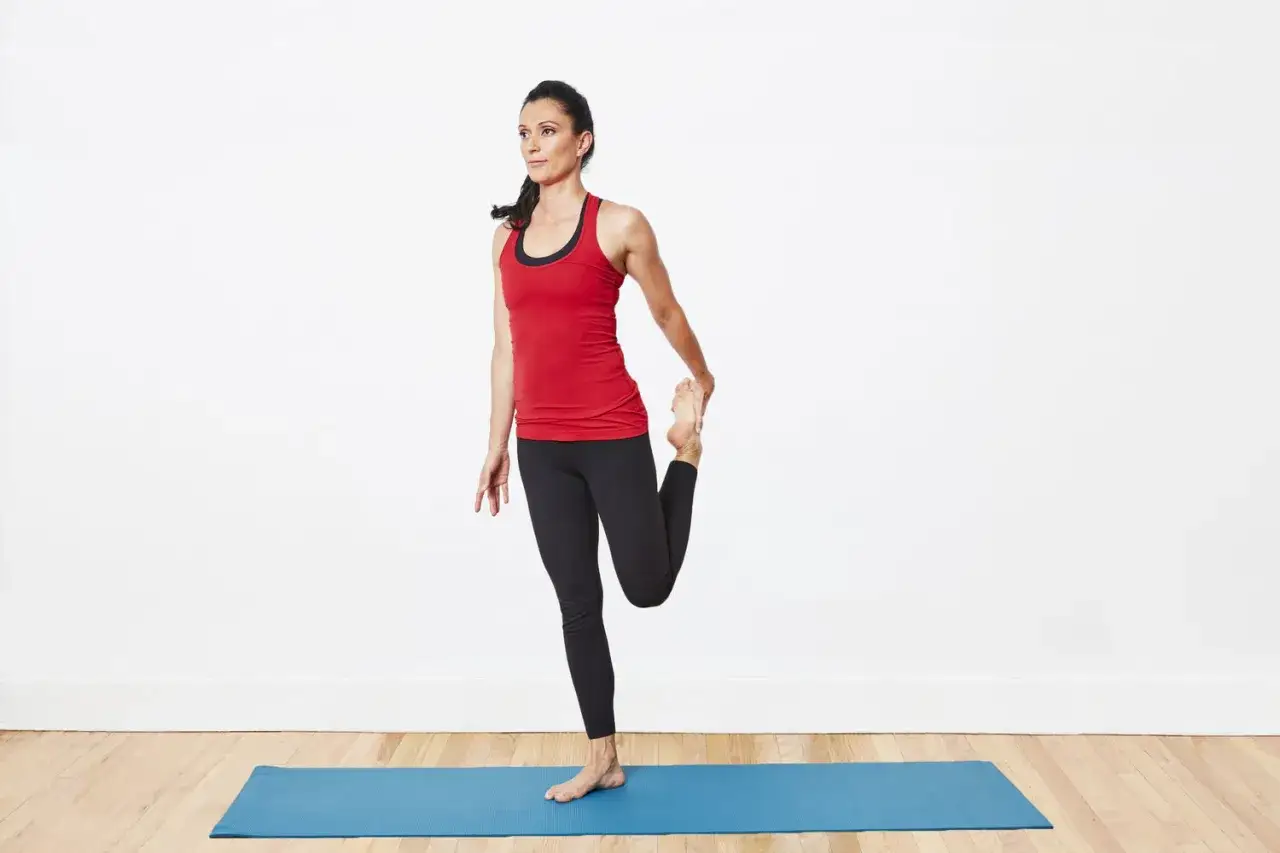 Donna in posa yoga allunga il quadricipite, un ottimo rimedio per contratture.