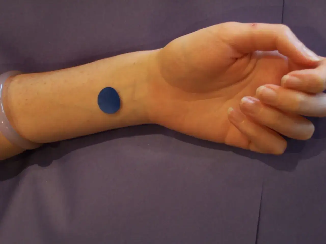 Polso con cerotto blu, un punto di digitopressione per reflusso gastrico.