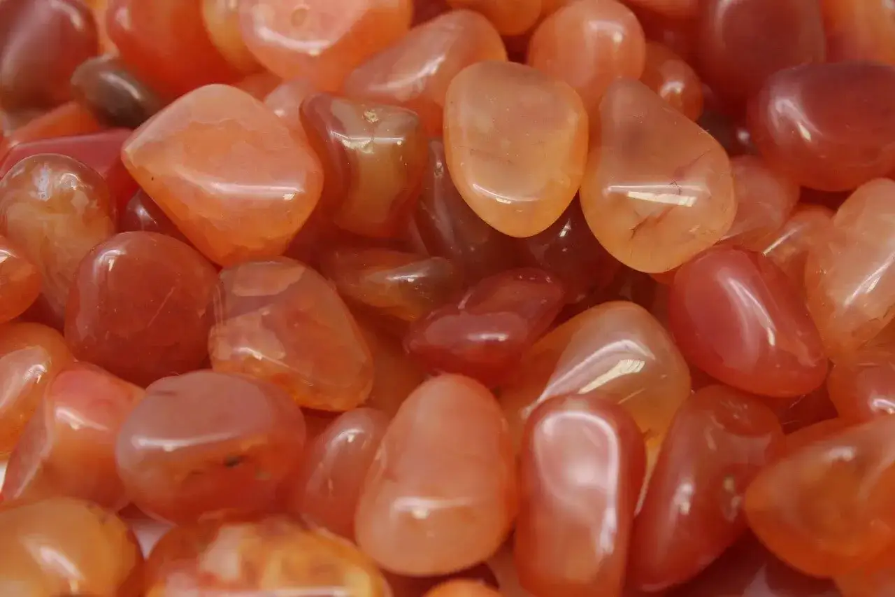 Tanti sassolini levigati color arancio e rosso, che ricordano il calore e il significato vitale dell'agata.