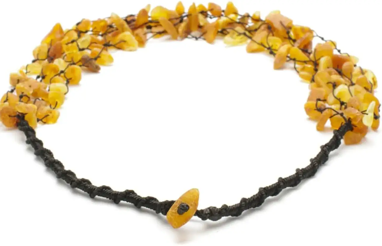 Collana grezza con ambra baltica grezza, nota per le sue propriet&agrave; benefiche. Pezzi irregolari di ambra dorata legati con filo nero.