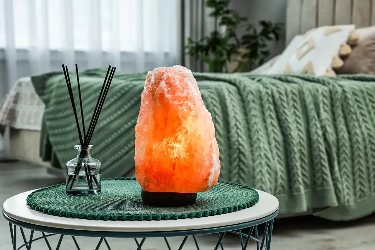 Lampada di cristalli di sale rosa illuminata, che crea un'atmosfera rilassante. I cristalli di sale a cosa servono? A purificare l'aria e donare benessere.