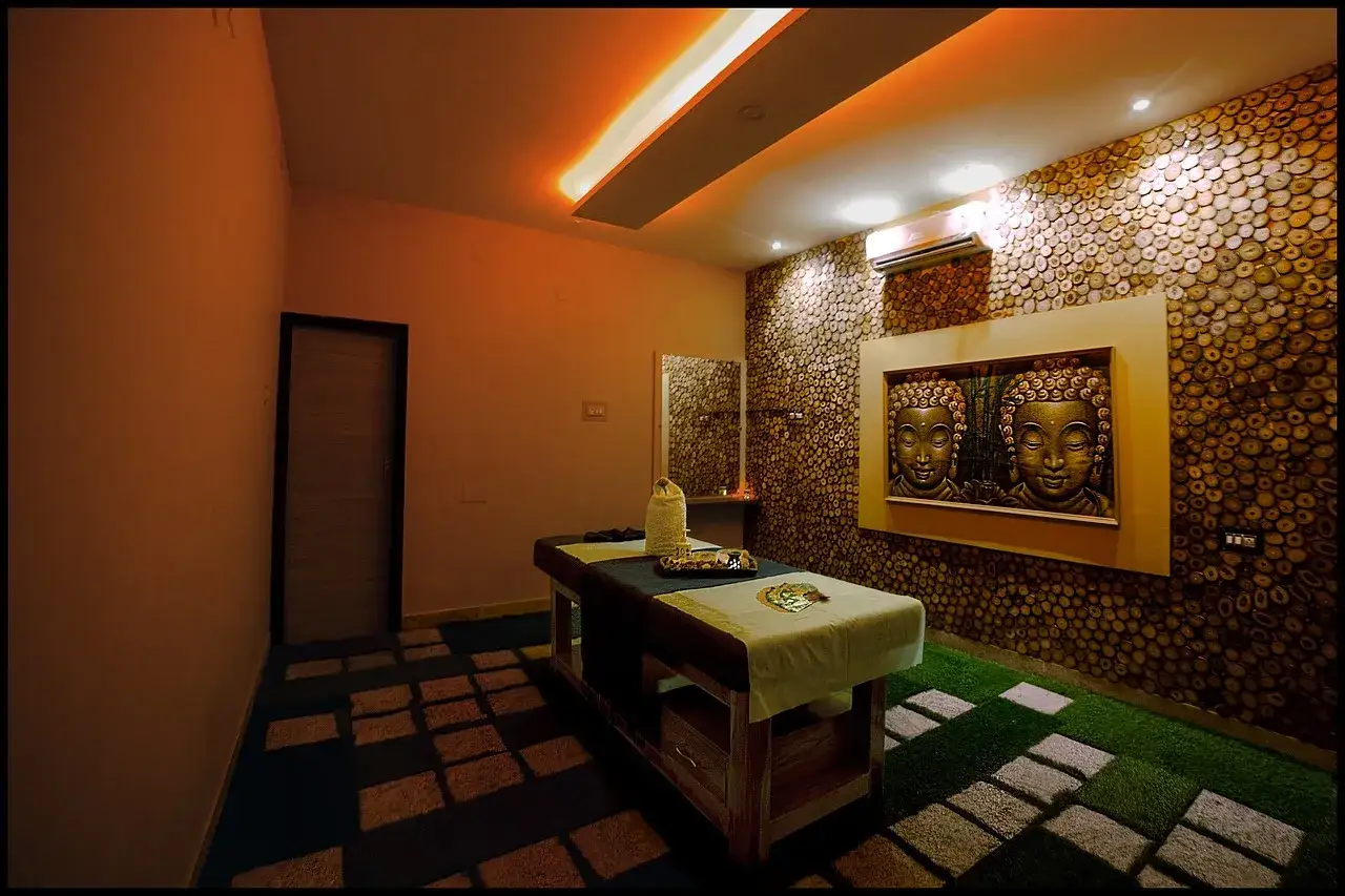 Stanza relax con lettino da massaggio, decorazioni a tema Buddha e un'atmosfera serena, ideale per un operatore olistico senza partita IVA.