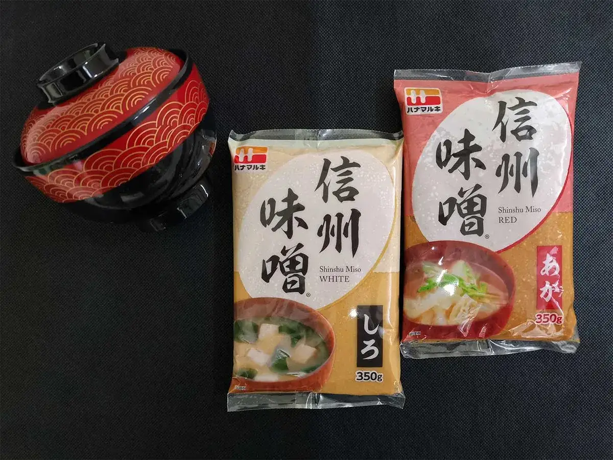 Due confezioni di miso bianco e rosso, ingredienti base per la zuppa, e una ciotola decorata. Che cos'&egrave; il miso? Un condimento fermentato.