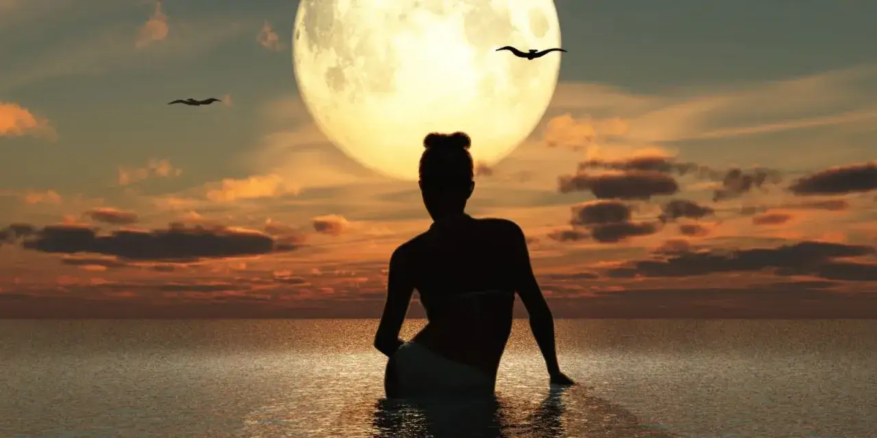 Silhouette di una donna in acqua, con la luna piena sullo sfondo. Un momento magico per chiedere un desiderio alla luna piena.