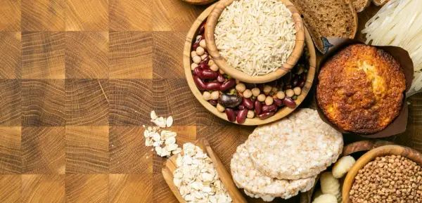 Varietà di alimenti: riso, fagioli, avena, muffin, gallette di riso, pasta e pane. Alcuni sono carboidrati raffinati quali sono, altri integrali.